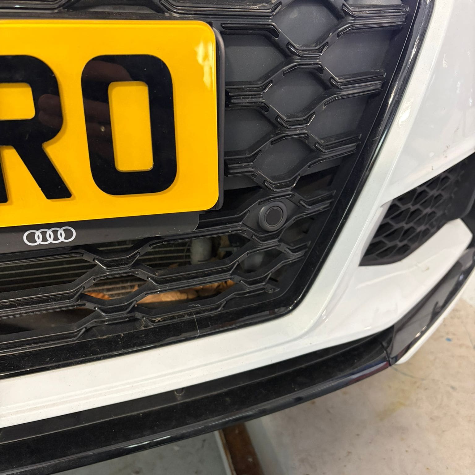 Audi TTS Mk2 front bumper showing color-coded corner sensors and center sensors mounted in OEM grille holders