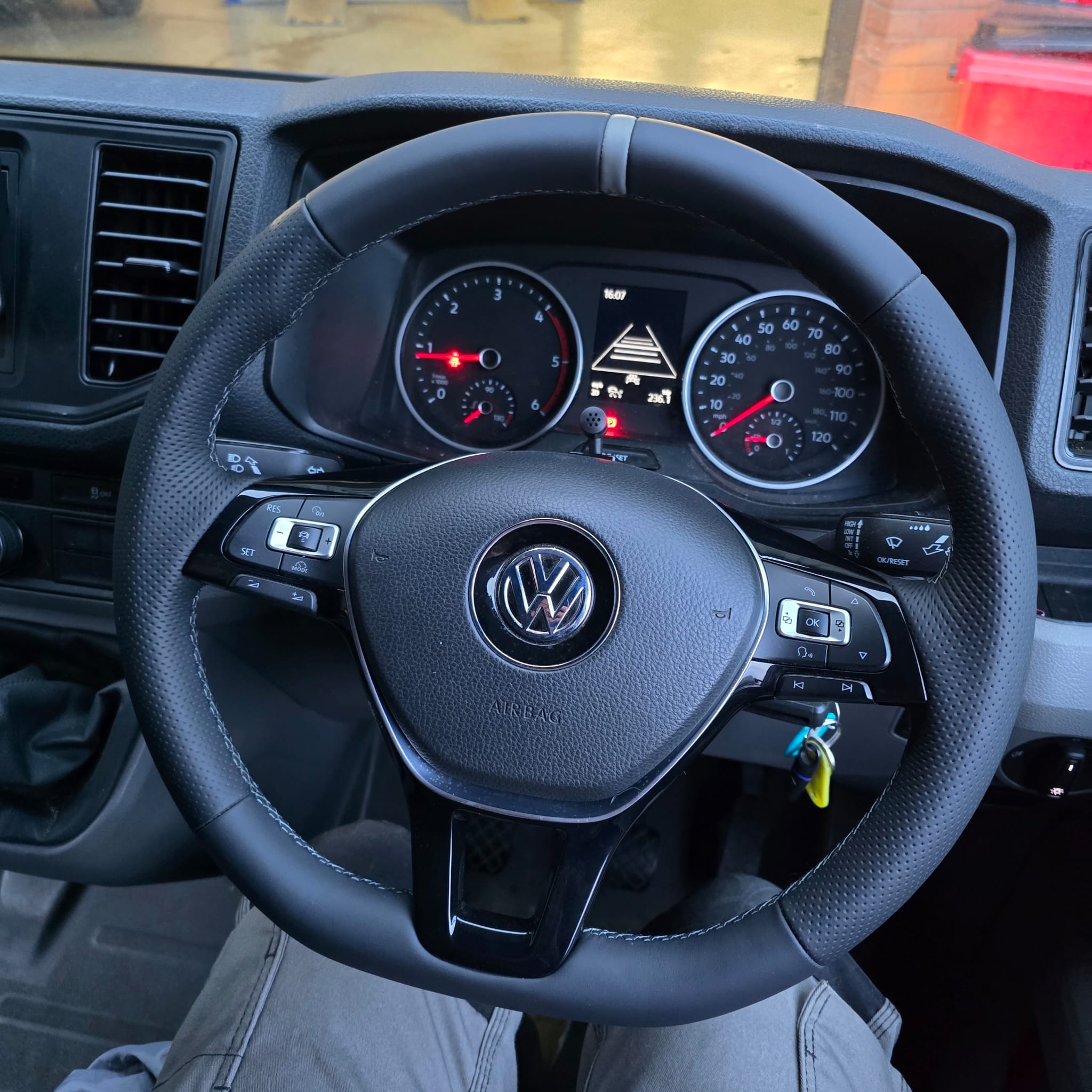 Close-up of grey-stitched custom flat-bottom steering wheel in VW Crafter