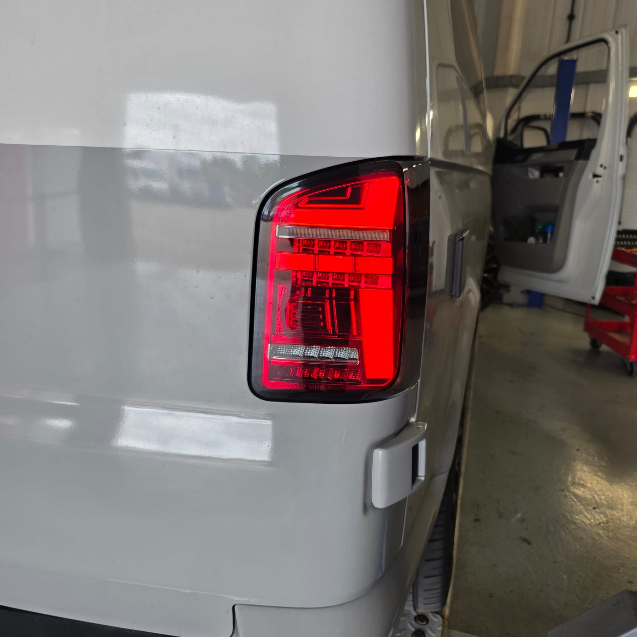 VW T6 barn door camper photographed after last-minute aftermarket LED tail light retrofit before France trip