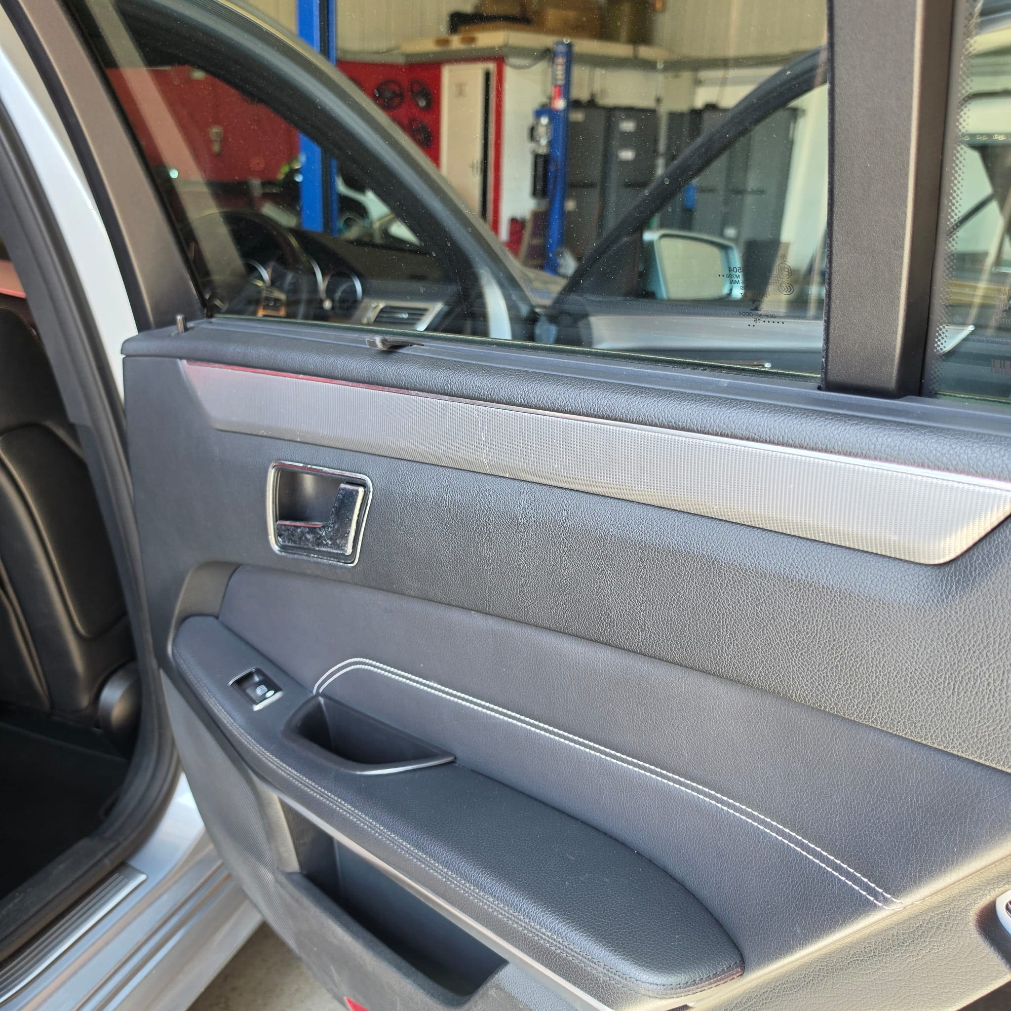 Mercedes E-Class interior trim replacement in progress with dashboard and door trim parts removed