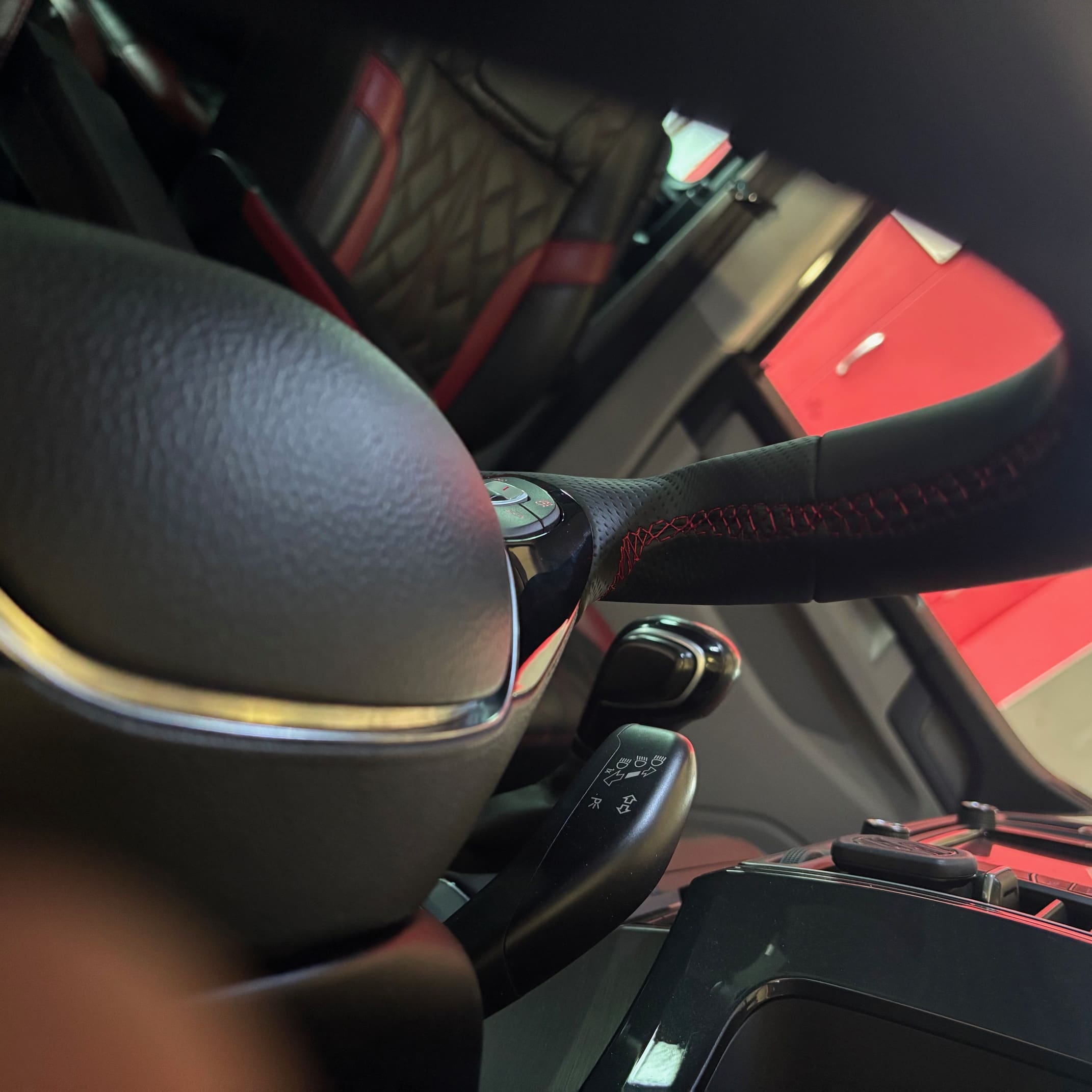 Installed BadBoy steering wheel retrim with smooth and perforated leather mix and red stitching