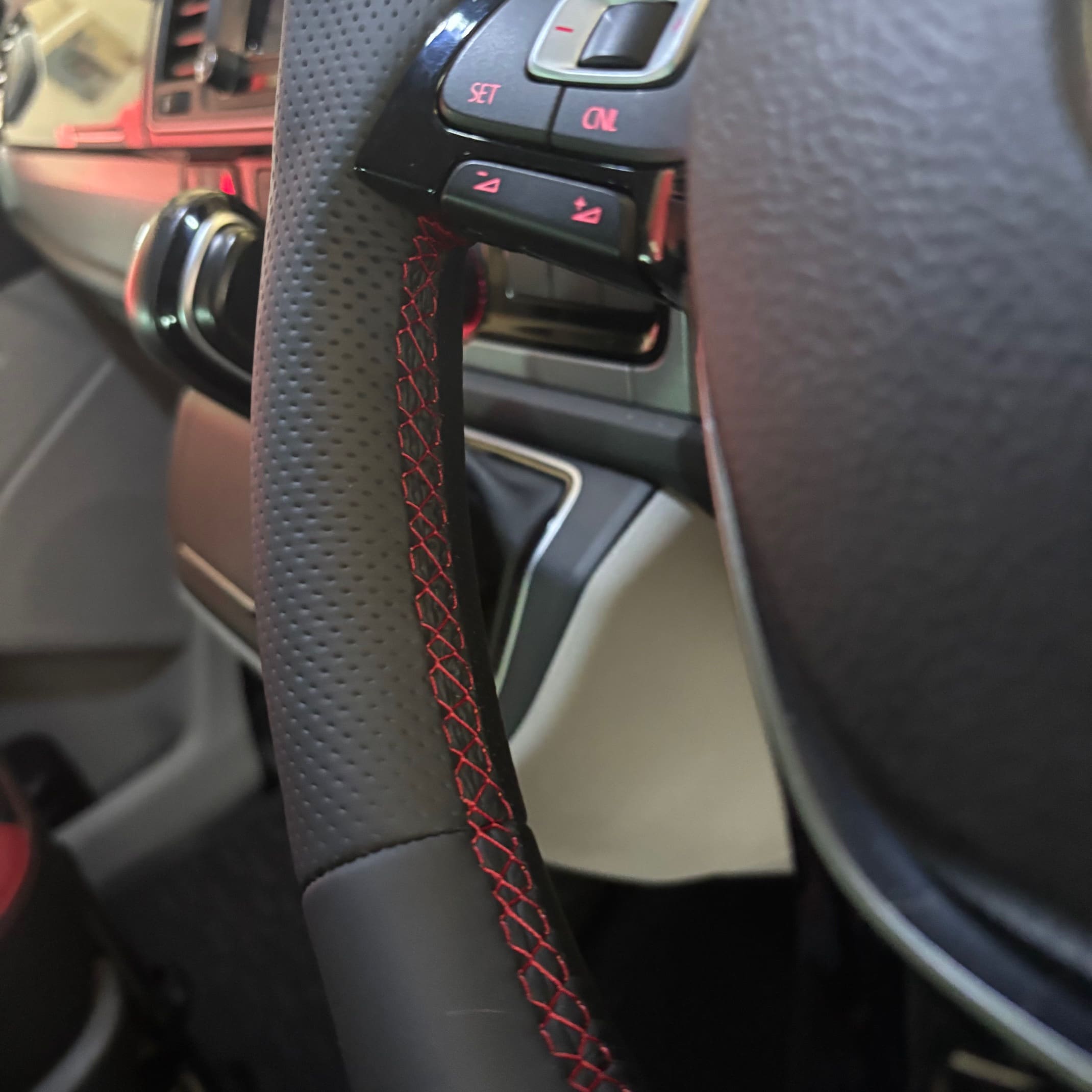 Close-up of red stitching and smooth plus perforated leather on a BadBoy steering wheel retrim
