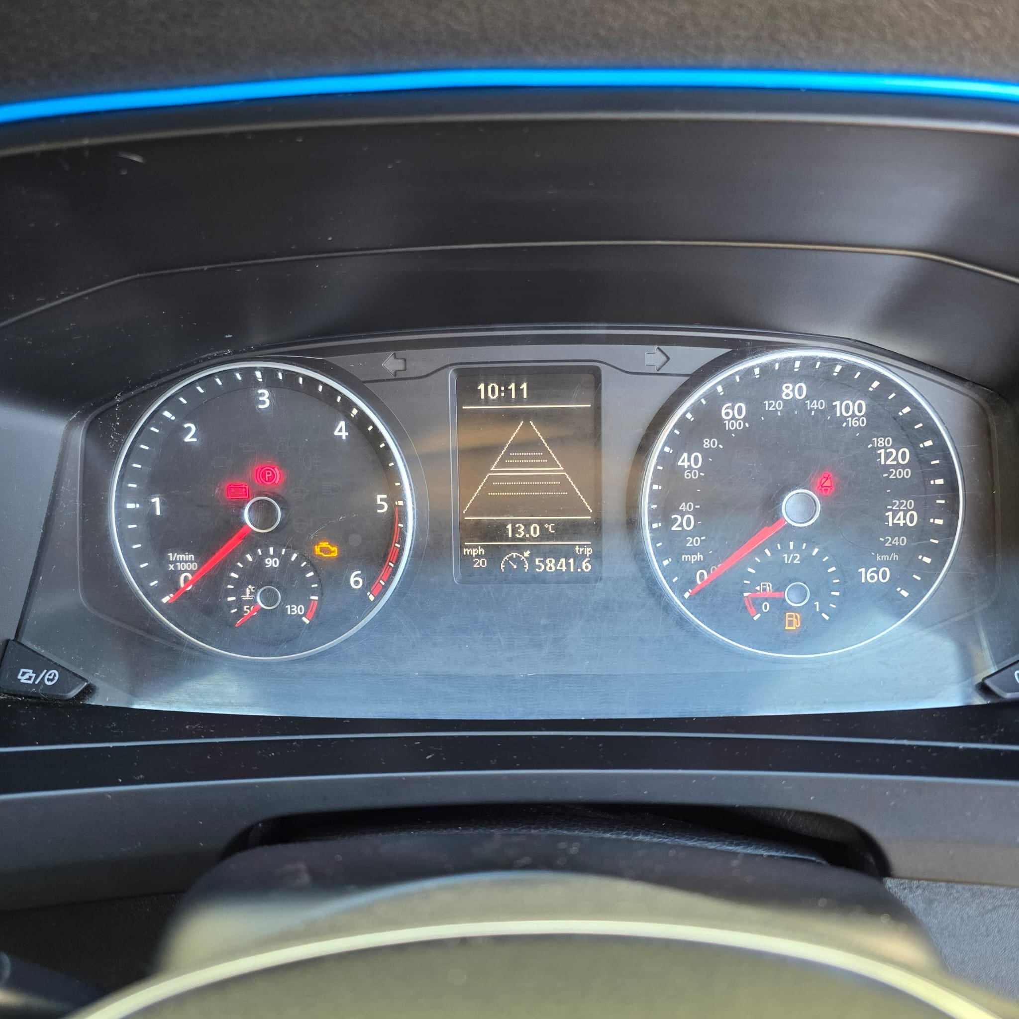Close-up of interior details including the blue wrapped steering wheel in the VW Transporter