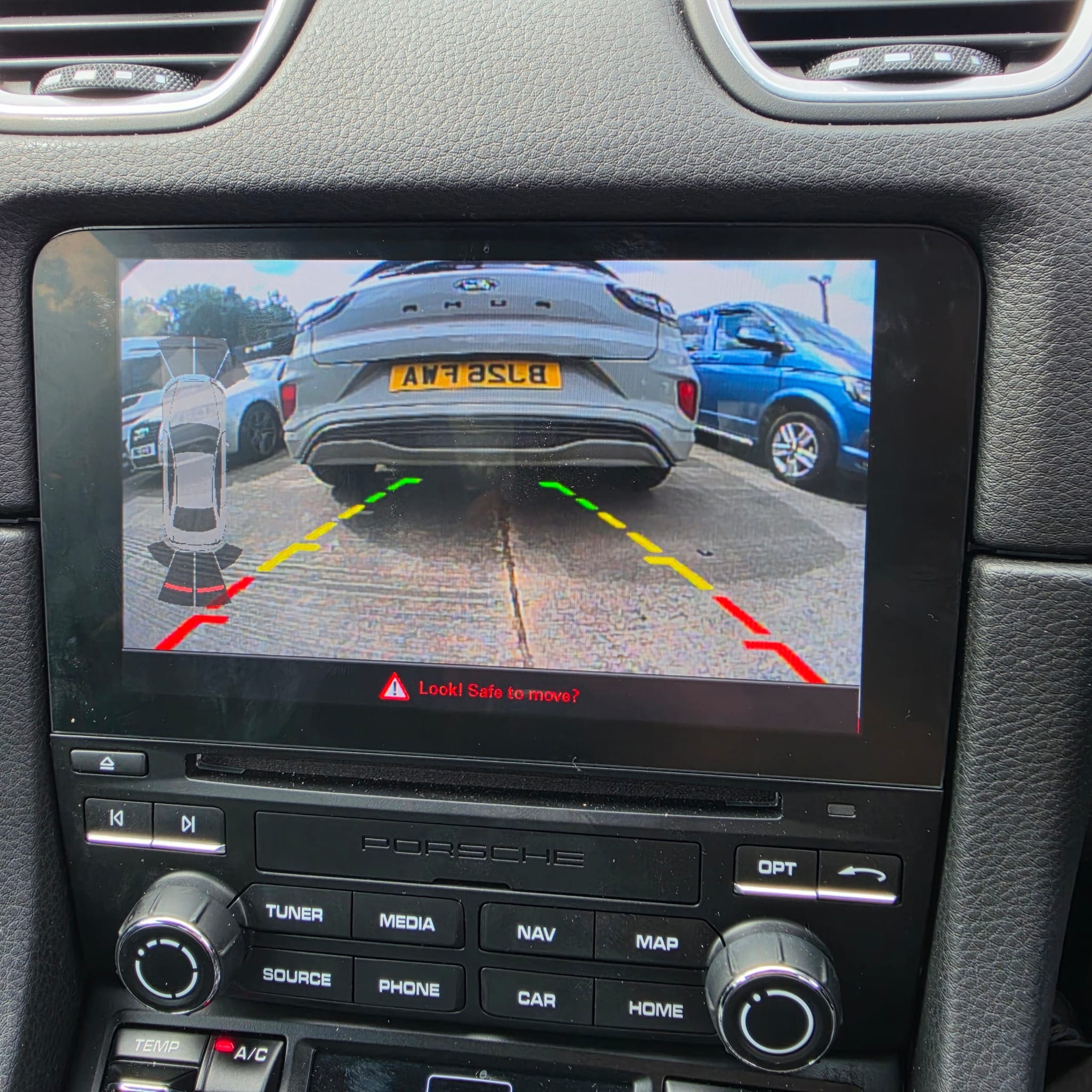 Porsche 718 Cayman camera retrofit showing OEM stereo and parking aid integration