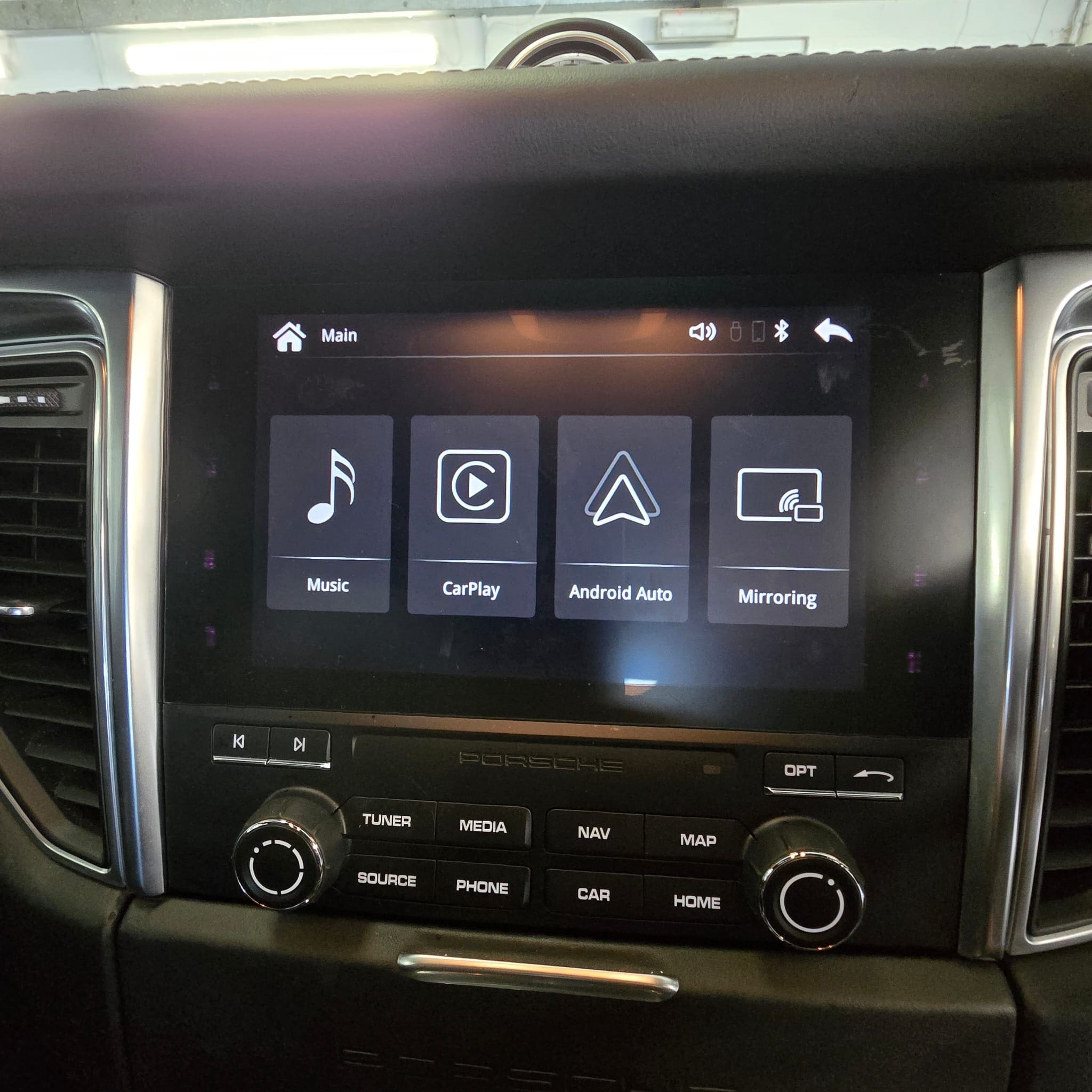 Hidden Apple CarPlay integration hardware installed behind the glovebox in a Porsche Macan
