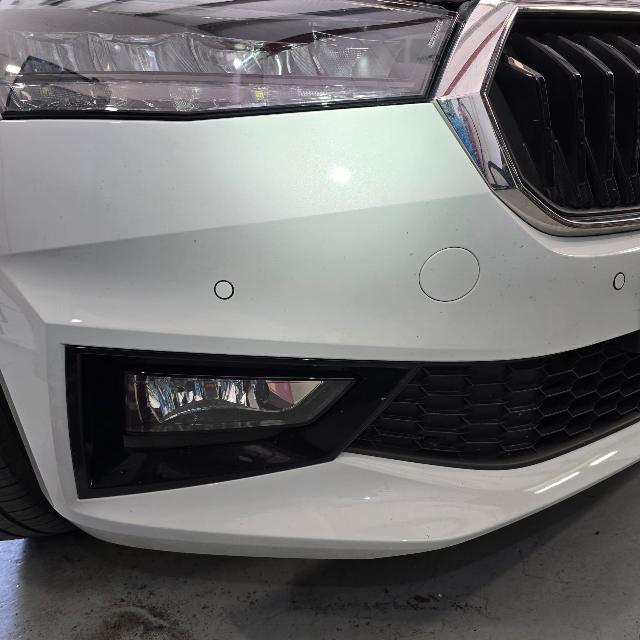 Front bumper area of a Skoda Fabia 2025 during OEM parking sensor retrofit work