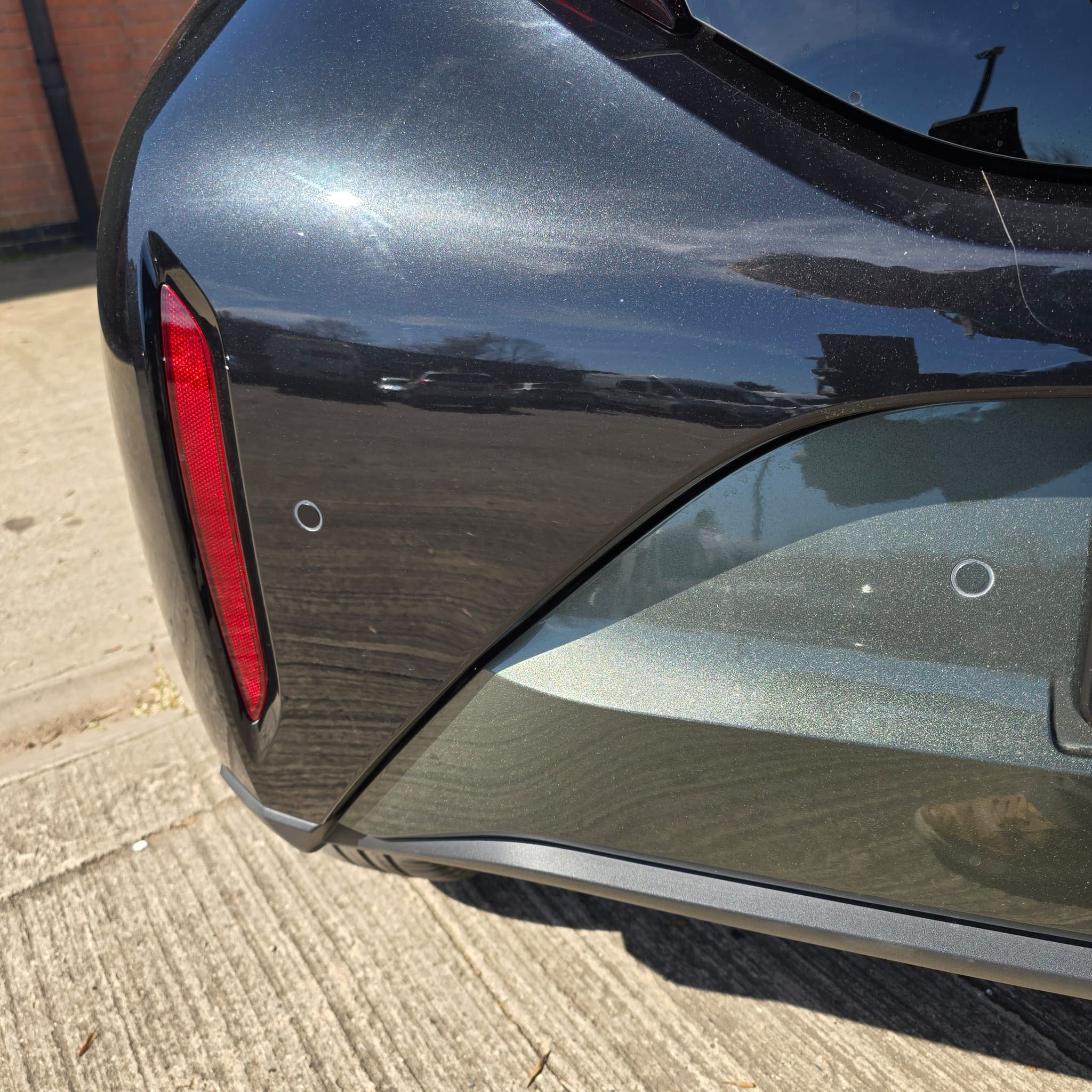 Close-up of flush-fit Vodafone rear parking sensor in a Toyota Aygo X Edge bumper