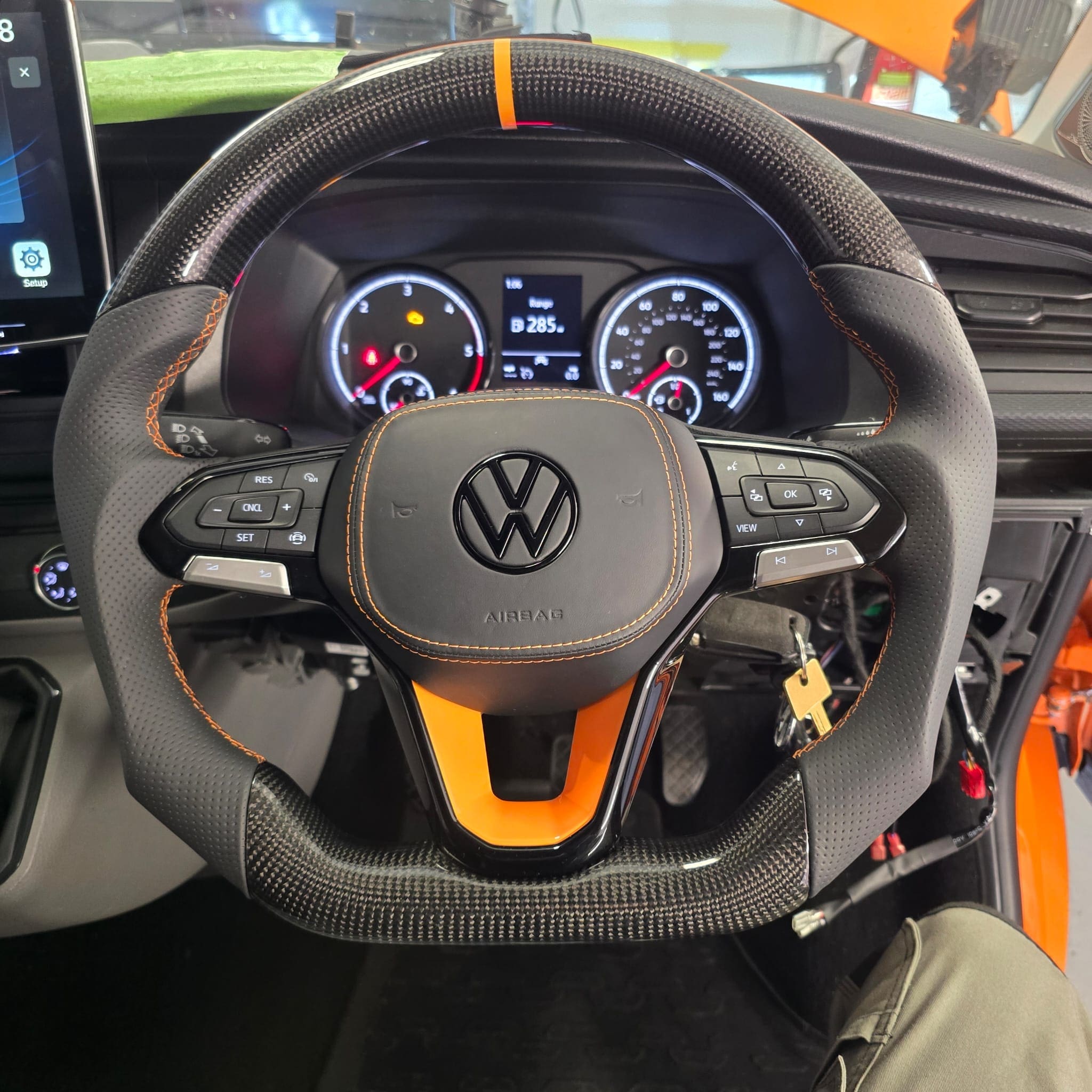 Close-up view of orange stitching and perforated grip sections on the fitted steering wheel