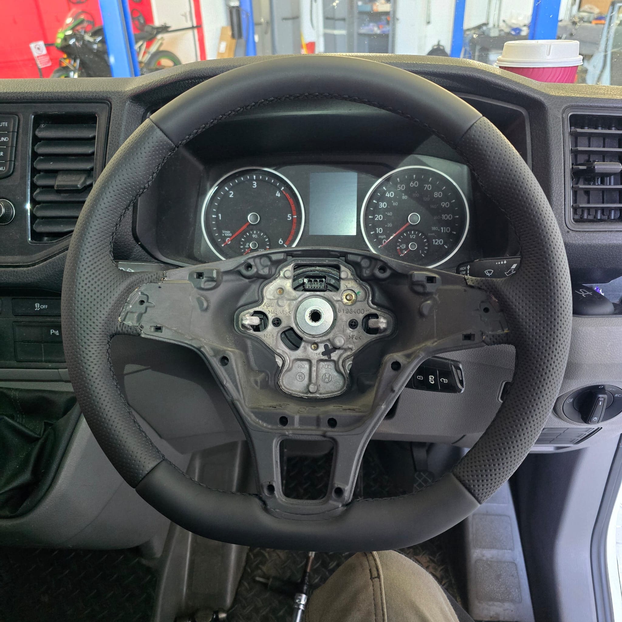 Perforated side grip sections on the custom retrimmed flat-bottom steering wheel in a Volkswagen Crafter