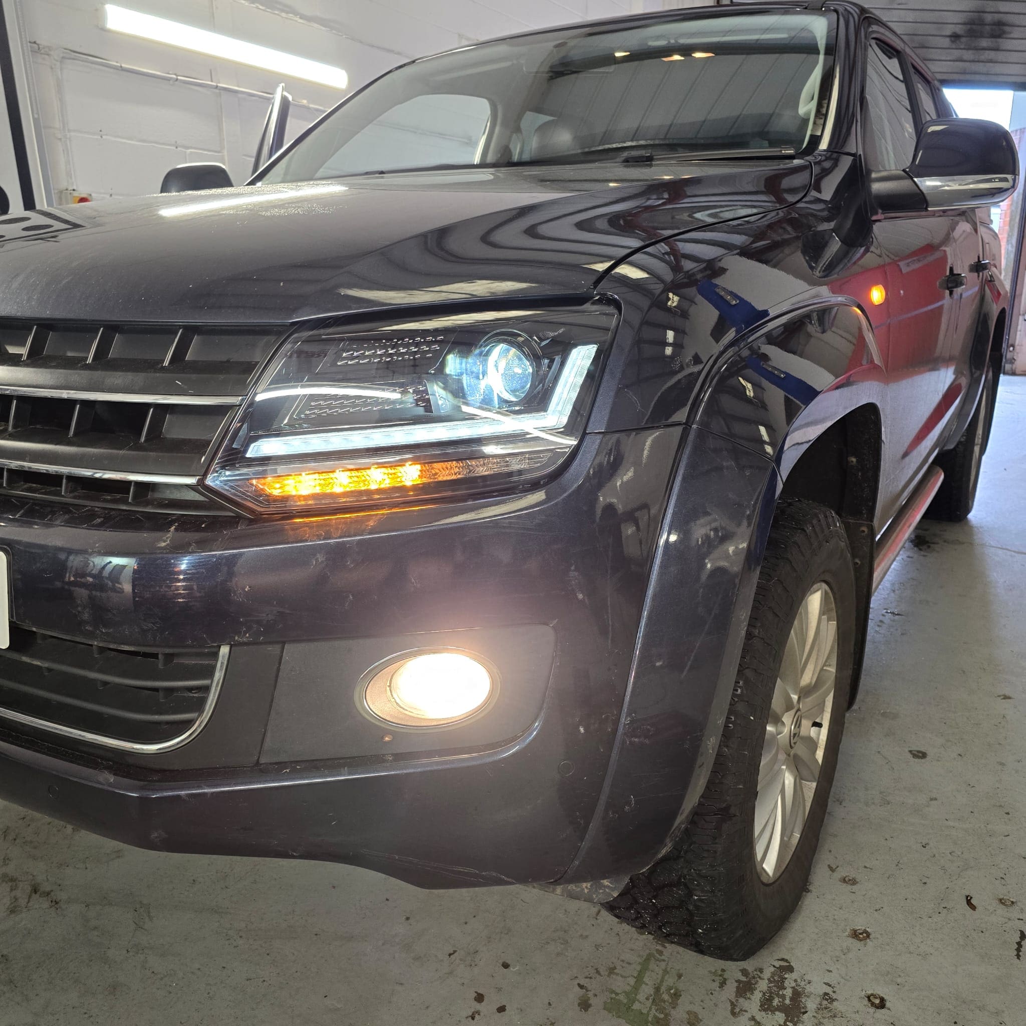 Close-up view of the black OSRAM LED headlamp upgrade on a VW Amarok