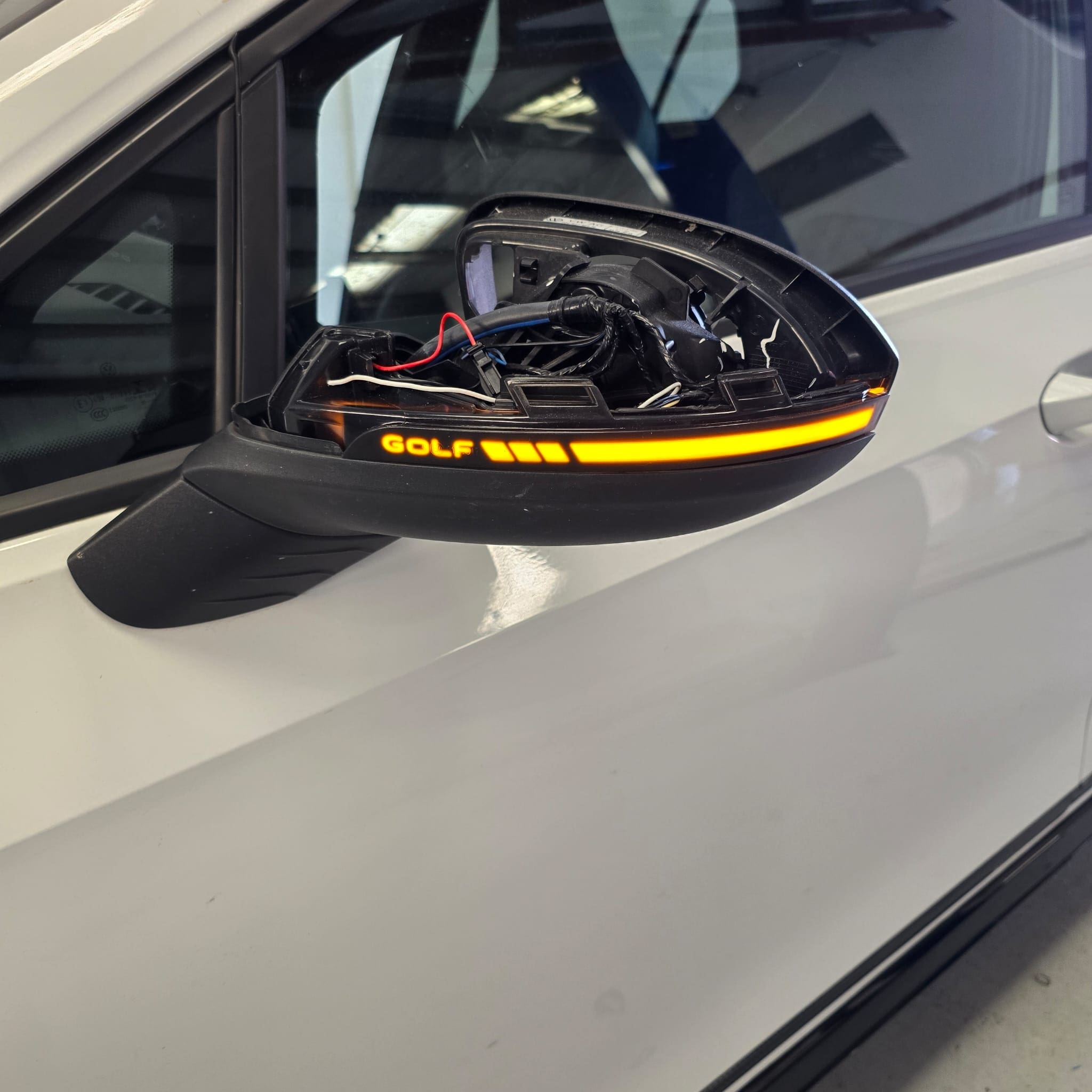Close-up of VW Golf Mk8 mirror indicator upgrade showing sequential lighting style