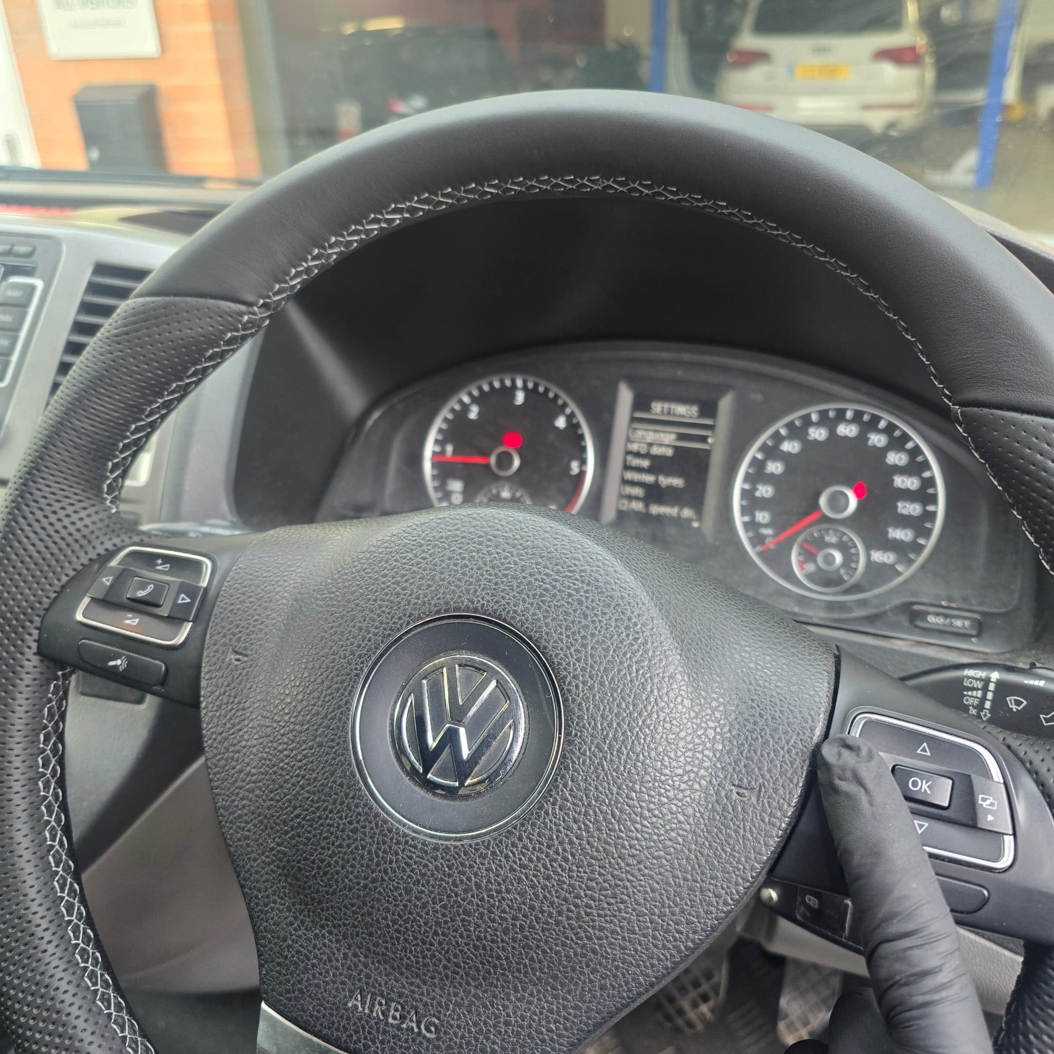 Detail shot of grey stitching and leather seam alignment on a VW T5.1 steering wheel retrim