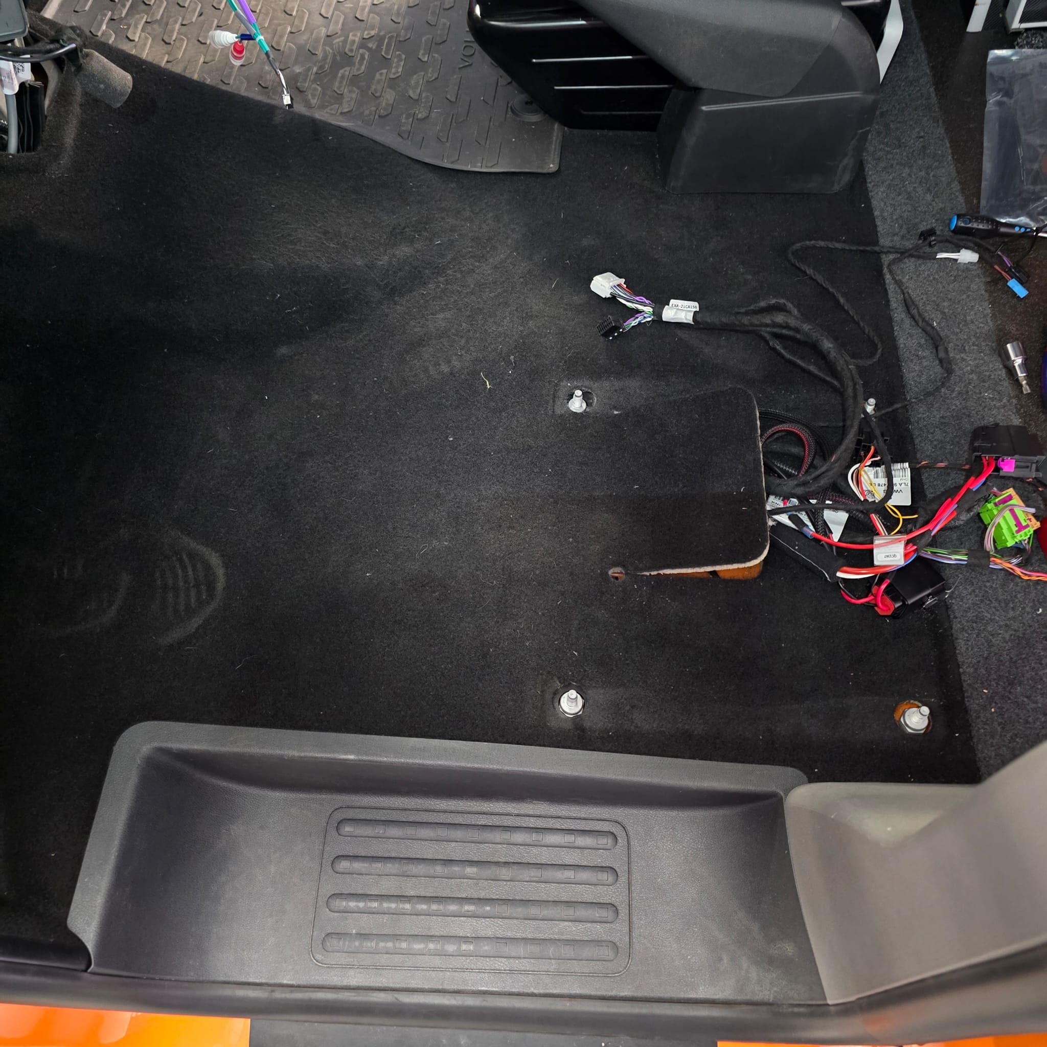 Passenger seat base area showing the Alpine amplifier and subwoofer package installed neatly