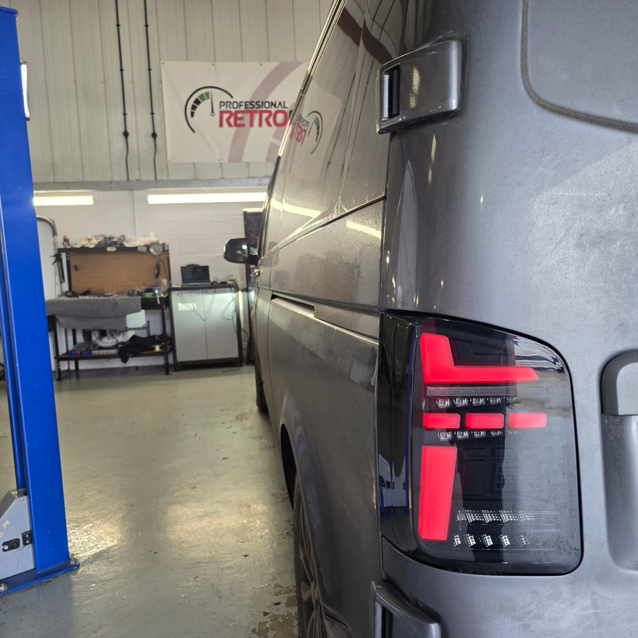 VW Transporter T6.1 rear view after fitting Transporter HQ smoked LED tail lights on a dark blue van