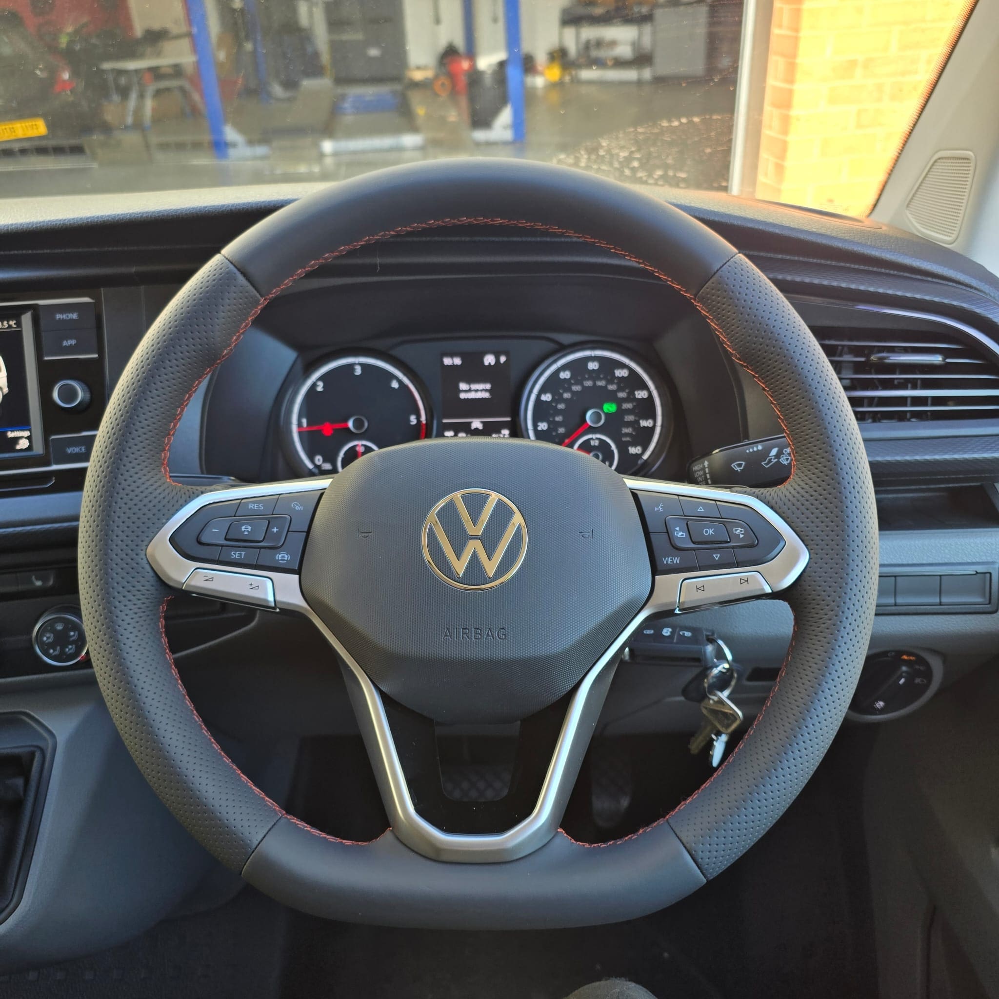Close-up of orange stitching line around the steering wheel rim after retrim
