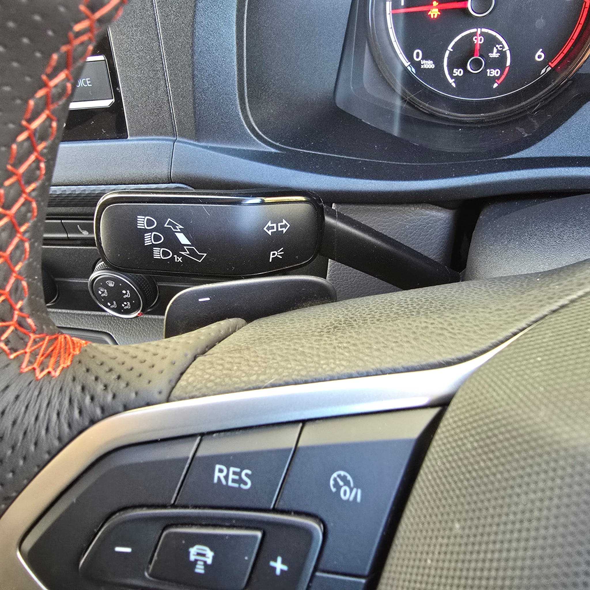 Steering wheel retrofit detail showing smooth top and bottom sections with orange stitching