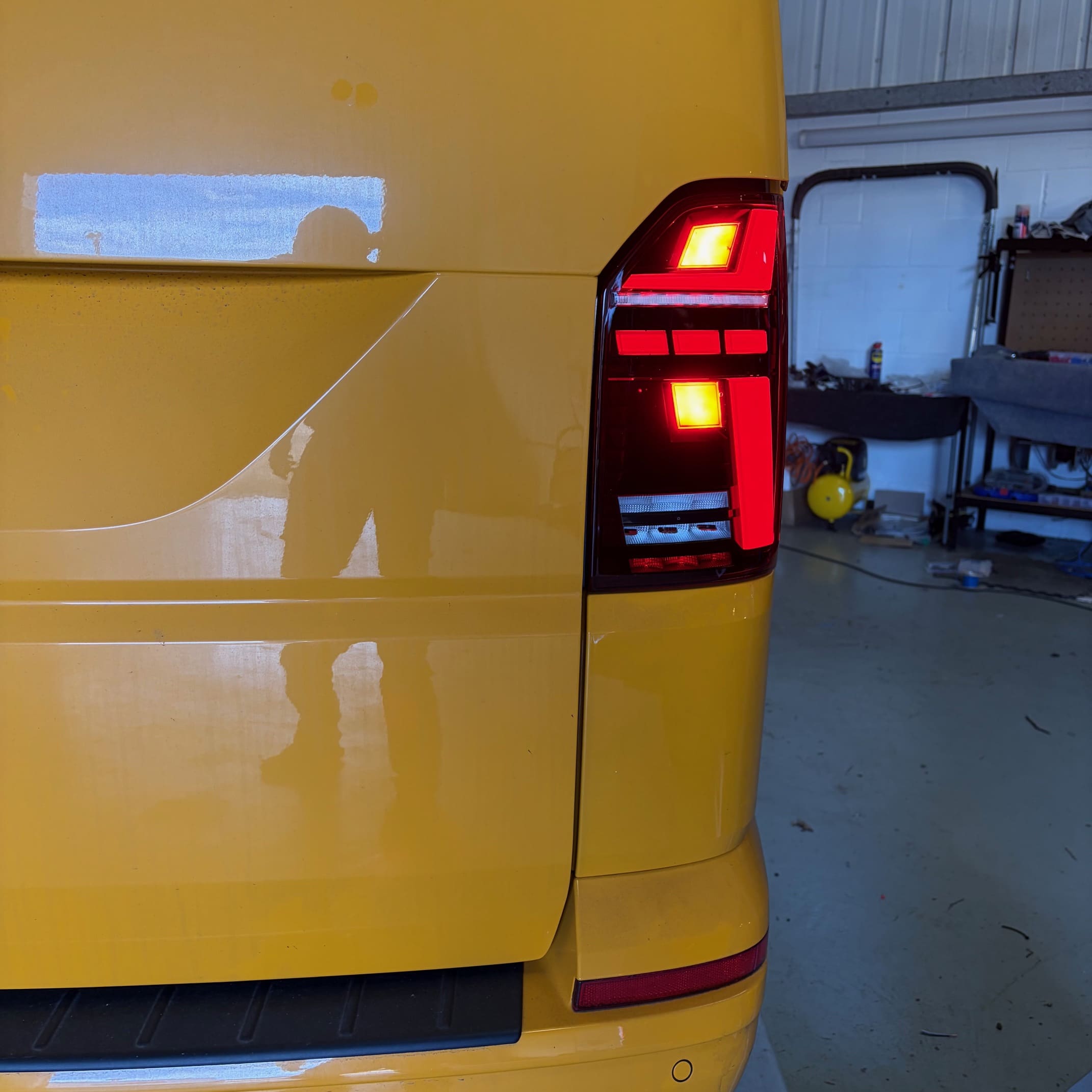 Close-up view of the smoked LED taillight on a VW T6.1 after retrofit installation