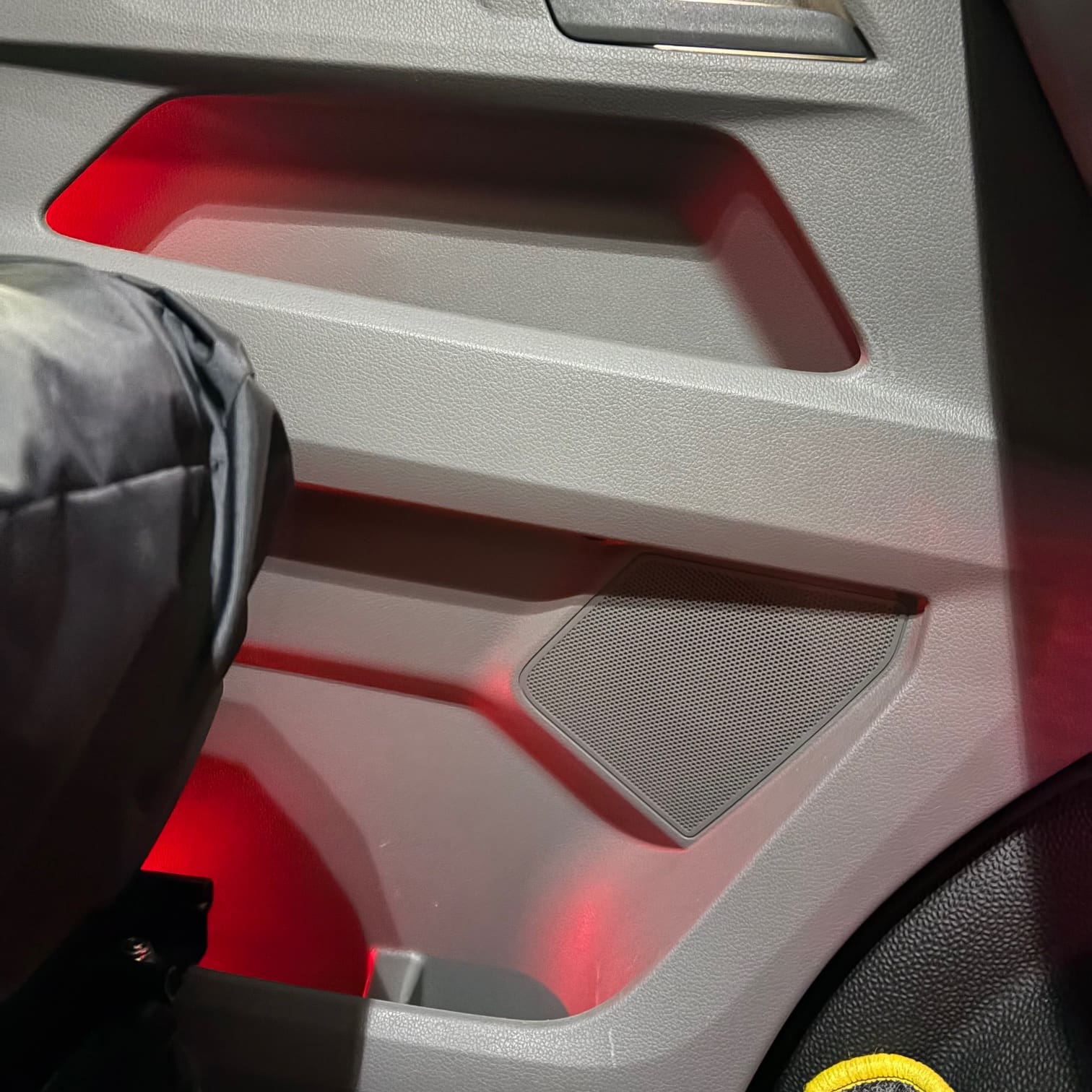 VW Transporter interior showing red ambient footwell glow and white door handle illumination
