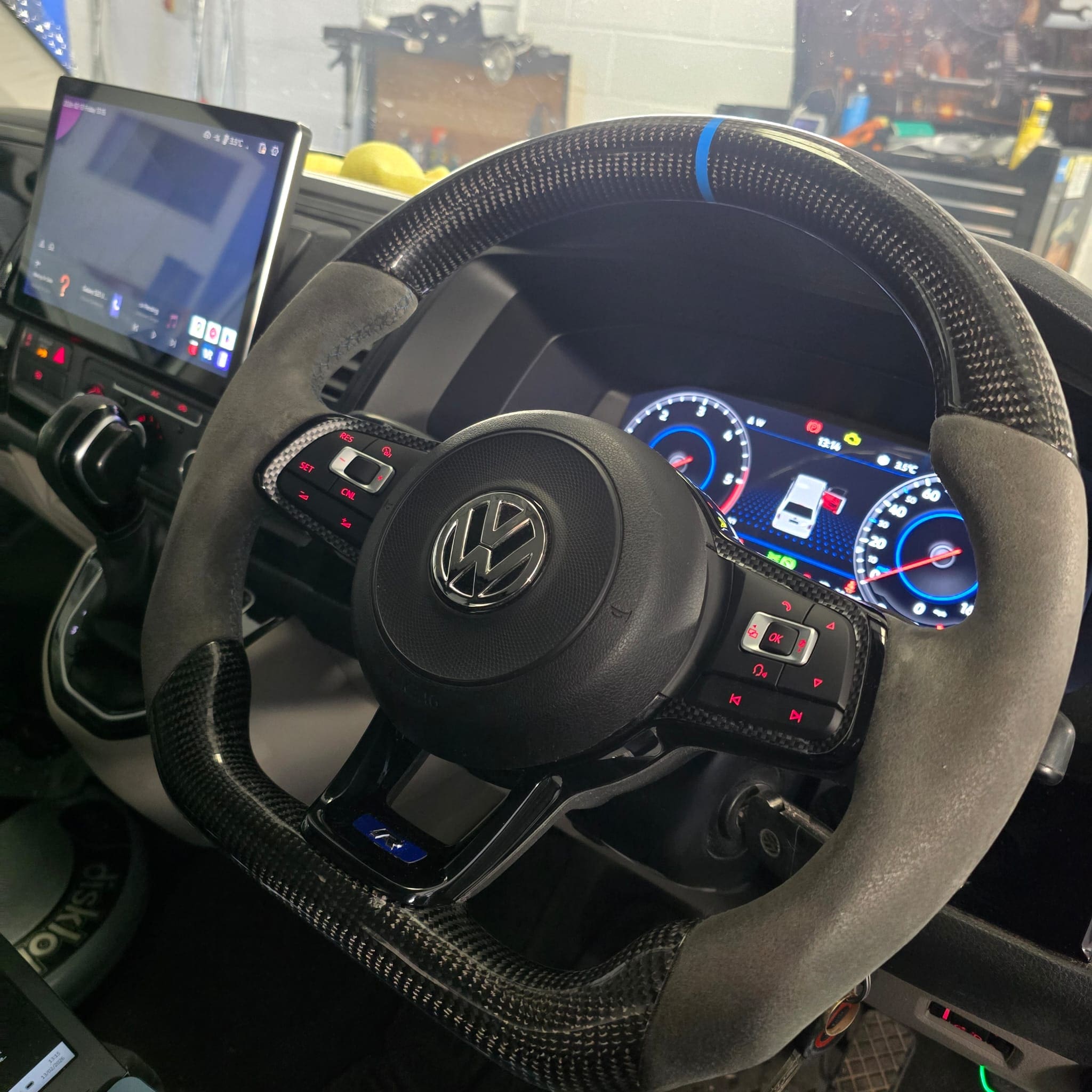 Transporter T6 carbon steering wheel upgrade showing 1K0 cruise control buttons and DSG paddles with blue 12 o'clock band