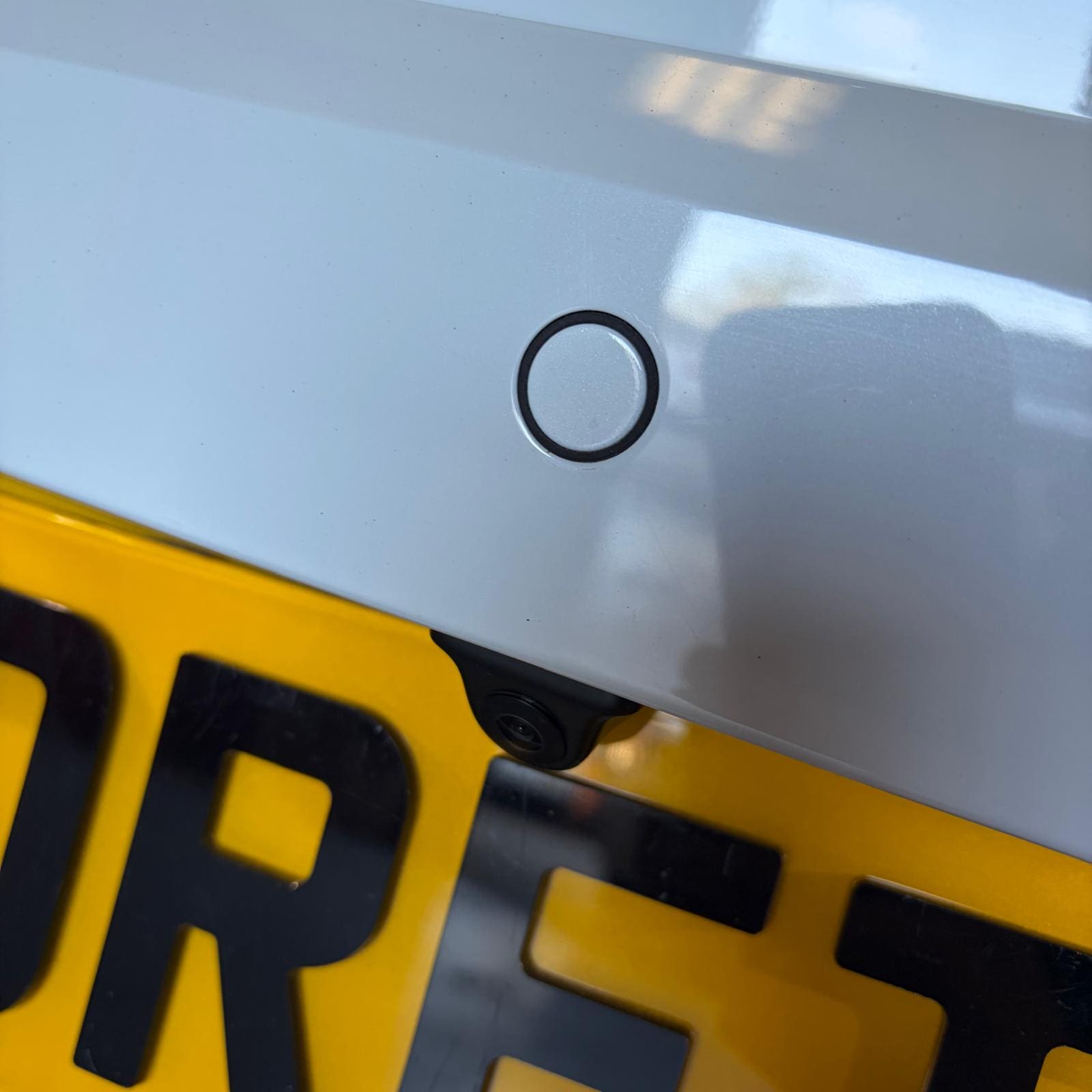 White Seat Ibiza FR Mk3 in the workshop after front and rear OEM parking sensors retrofit and rear view camera install